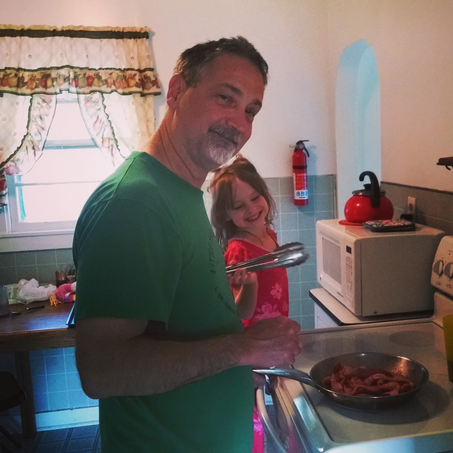Dr. McVey with his granddaughter cooking bacon