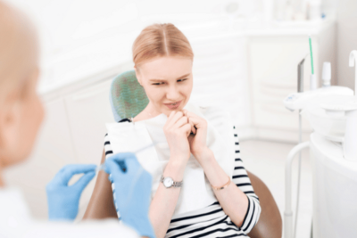 Teen smiling while holding SimplyClear clear aligners at Randall K. McVey, DMD PA in Garden City, KS