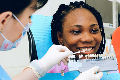 Teeth Whitening Garden City KS Woman getting her teeth color matched for professional teeth whitening treatment