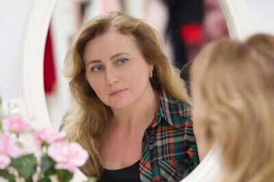 Woman looking at her new smile in the mirror during Trial Smile preview Woman looking at her new smile in the mirror during Trial Smile preview