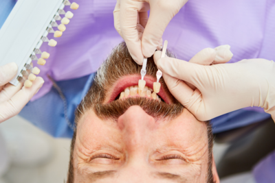 Veneers and Crowns Garden City KS Man getting teeth color matched for veneers at dental office